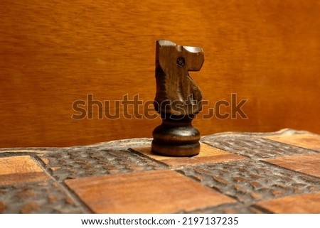 Part of a chess game. Knight or horse. Wooden piece. Close up and isolated.