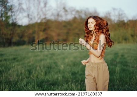 A woman is jogging with a focused face, tired after an outdoor activity