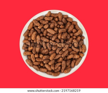 White bowl with natural organic granola cereal chocolate flakes on red background. Oven-toasted rice cereal and the flavor chocolate. Top view Royalty-Free Stock Photo #2197168219
