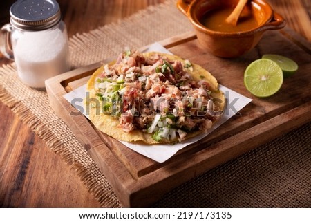 Taco de Carnitas. Cornmeal tortilla with deep fried pork. Traditional Mexican appetizer commonly accompanied by cilantro, onion and hot sauce.