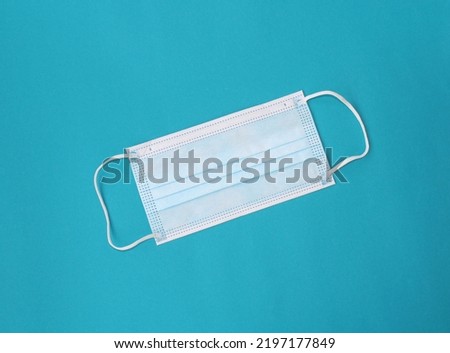 Medical face mask isolated on blue background. Three-layer. Corona protection, pollution, virus, flu concept.