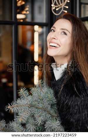 Portrait of young woman sitting in cafe in winter town and posing for a photo