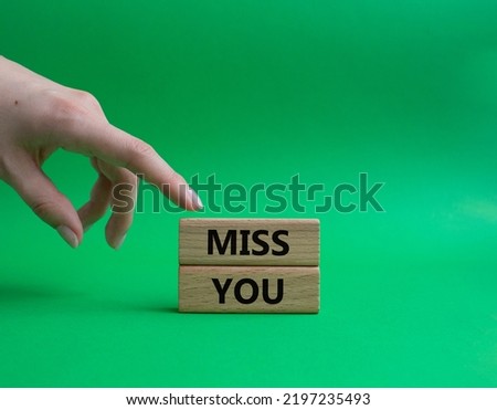 Miss you. Concept word Miss you on wooden cubes. Beautiful green background. Businessman hand. Business and Miss you concept. Copy space.