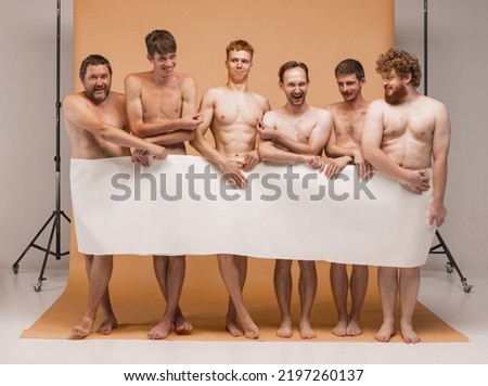 Funny activists. Six cheerful shirtless men standing with huge blank white paper banner over yellow background. Body positivity and natural bodies, diversity, ad concept.