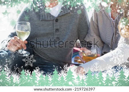 Couple enjoying white wine on picnic at the beach against snow