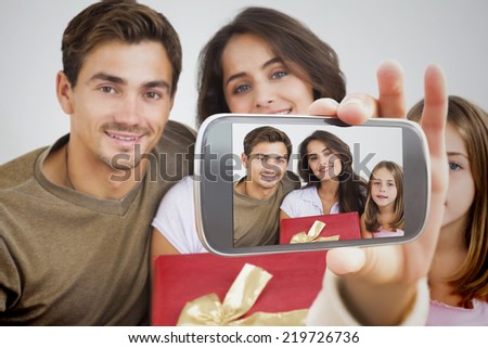Composite image of hand holding smartphone showing photograph