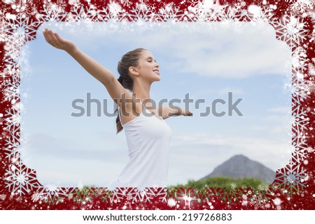 Beautiful woman with arms raised against sky against snow