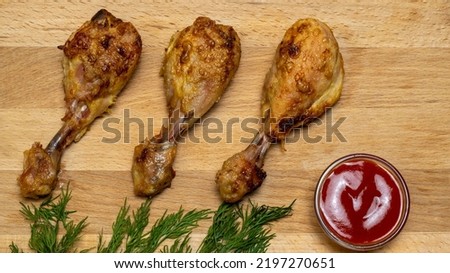 Three fried chicken legs on a wooden background. Background picture.