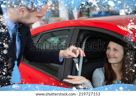 Composite image of customer receiving car keys against snow