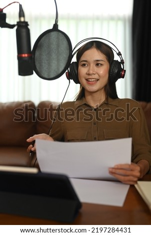 Asian woman podcaster wearing headphone recording podcast from home studio. Radio, podcasts, blogging and technology concept