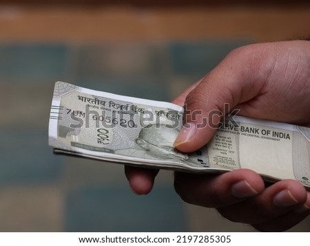 Concept currency Shot of young  guy holding of Indian rupees. Close up of hand counting Indian Money. 4K video. New Indian currency notes. 500 Indian Rupee notes. paying in cash. Royalty-Free Stock Photo #2197285305