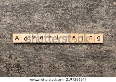 ADVERTISING word written on wood block. ADVERTISING text on cement table for your desing, concept.
