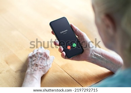 Phone call to old woman from scam or fraud caller. Elder senior answering to unknown number. Smartphone scammer or mobile hoax, catfish or phishing concept. Stalker or stranger. Grandma with cellphone Royalty-Free Stock Photo #2197292715