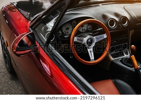 leather interior and sports steering wheel of a red convertible. car exterior Royalty-Free Stock Photo #2197296121