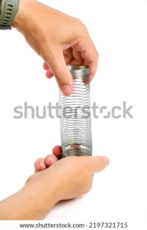 Metal spring antistress toy,slinky, in hand white background Royalty-Free Stock Photo #2197321715
