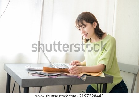 Woman choosing cloth samples at desk