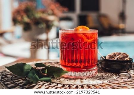 Negroni at poolside. Classic cocktail Negroni with gin, campari and martini rosso. Traditional recipe Royalty-Free Stock Photo #2197329541