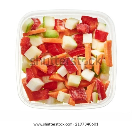 Chopped mix of vegetables in plastic container. Top view of raw vegetables isolated on white background. Preparing vegetables for freezing. Storage for winter storage in trays