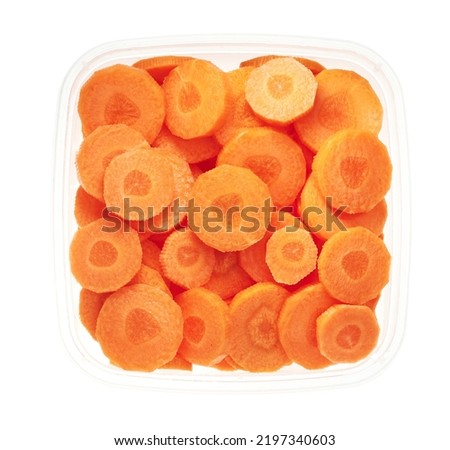 Slices of carrots plastic container. Top view of raw vegetables isolated on white background. Preparing vegetables for freezing. Storage for winter storage in trays