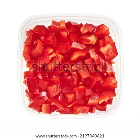 Chopped bell peppers in plastic container. Top view of raw vegetables isolated on white background. Preparing vegetables for freezing. Storage for winter storage in trays