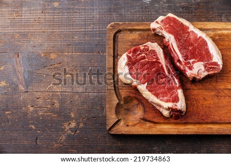 Raw fresh meat Ribeye Steak on dark background Royalty-Free Stock Photo #219734863