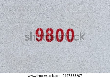 Red Number 9800 on the white wall. Spray paint.

