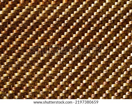 Close up bulletproof material aramid. Aramid kevlar background. Golden kevlar texture and pattern. 