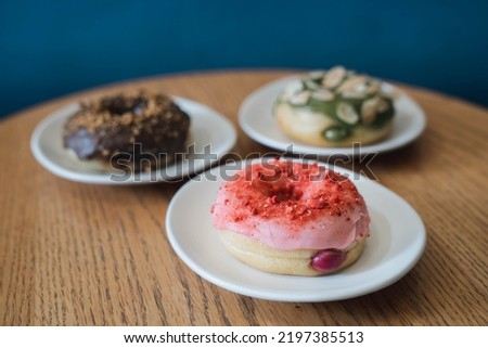 Colorful Tasty Cream-filling Donuts Serving on White Ceramic Plates