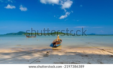 Boats in Rawai beach, Phuket, Thailand. The beach of Rawai on the island, with traditional long tail fishing boat anchored on the beach.