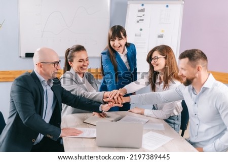 A team of young business people are chanting a team slogan together in the office. Royalty-Free Stock Photo #2197389445