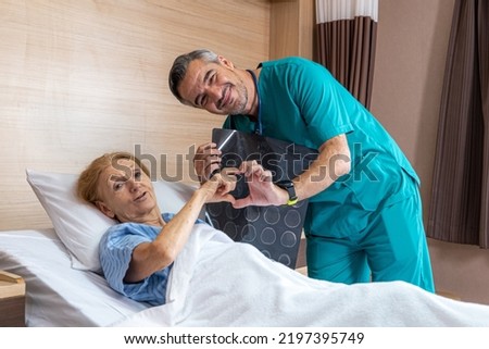A doctor medical worker in uniform with stethoscope around neck is using hand to make heart symbol with senior patient to cheer her up while also holding human brain skeleton x-ray film background.