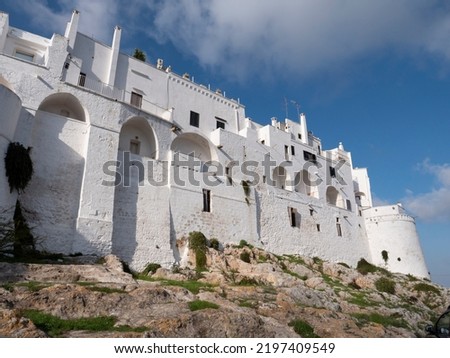 White walls of the Ostuni city fortification in Italy at sunset with blue sky