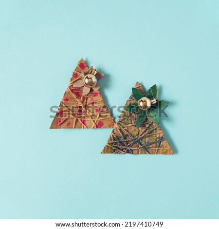 Recycled cardboard Christmas trees wrapped with rope. Flat lay view with flower detail.
