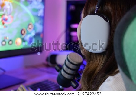 young female game streamer playing online game on computer at home, Gamer woman wearing headsets taking on microphone with teammates, Gamer lifestyle, E-Sport online gaming technology