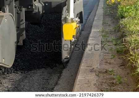 Asphalt paver. Laying of asphalt concrete mix. Background picture.