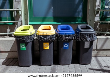 Colorful trash cans for sorting garbage. For plastic, glass, paper and others waste. Waste containers for garbage segregation in Poland, standing next to a wall Royalty-Free Stock Photo #2197436599