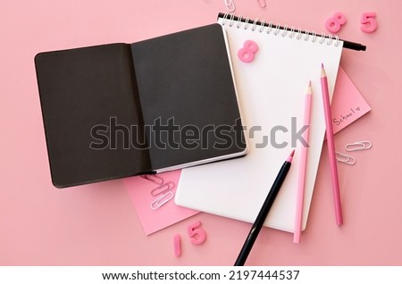 School supplies accessories stationery on pink background, flat lay, top view. Education supply accessory open empty notebook stuff. Back to school desk concept. Flatlay from above. Copy space.