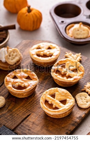 Halloween pumpkin pies with carved pumpkin or Jack-o-lantern face on top