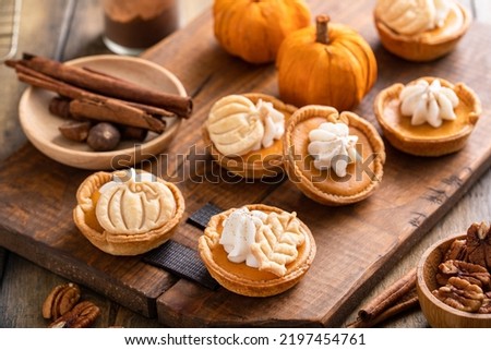 Mini pumpkin pies with wipped cream and spices baked in a muffin tin Royalty-Free Stock Photo #2197454761