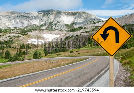 U-Turn Sign:  A sign warns motorists of a sharp bend ahead on a mountain road in southern Wyoming.  Royalty-Free Stock Photo #219745594