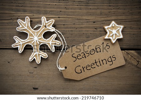 Season's Greetings written on a brown Banner with Ginger Bread Cookies with white Decoration
