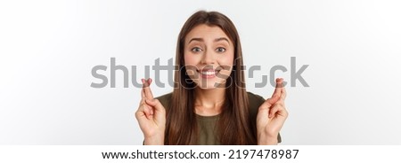 Closeup portrait hopeful beautiful woman crossing her fingers, open eyes, hoping, asking best isolated on gray wall background.
