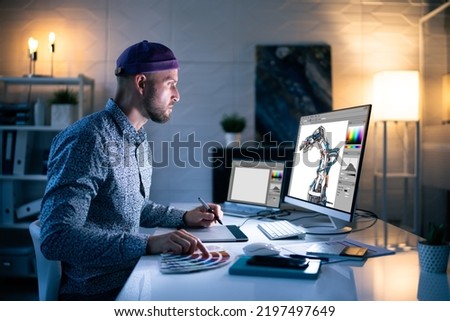 Graphic Designer Working Late At Night In Office