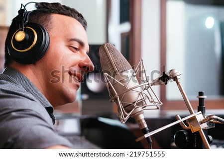 Man recording a song in the studio, side view
