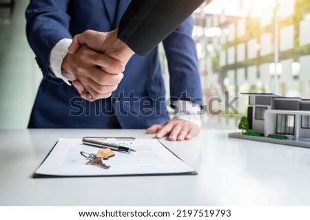 Shake hand Real estate brokerage agent Deliver a sample of a model house to the customer, mortgage loan agreement Making lease and buy and sell house And contract home insurance mortgage loan concept Royalty-Free Stock Photo #2197519793