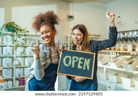 Young Woman Owner in Apron Selling Superfoods in Zero Waste Shop. .Small business: Happy owner of a cafe showing open sign.