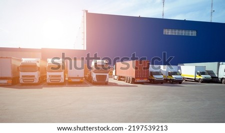 The glare of the sun over the logistics warehouse and large machines. Transportation of goods, logistics
