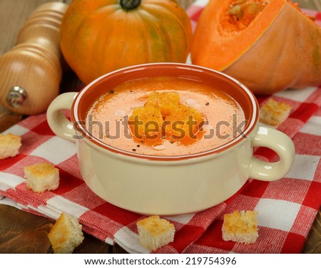 Pumpkin soup on brown background