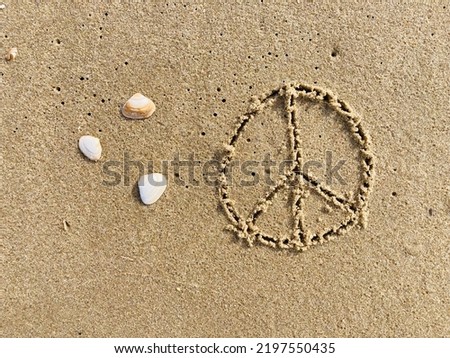 on the beach the peace symbol is carved into the smooth sand