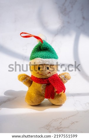 Ginger bread man plush doll isolated on white marble surface under sun light from window